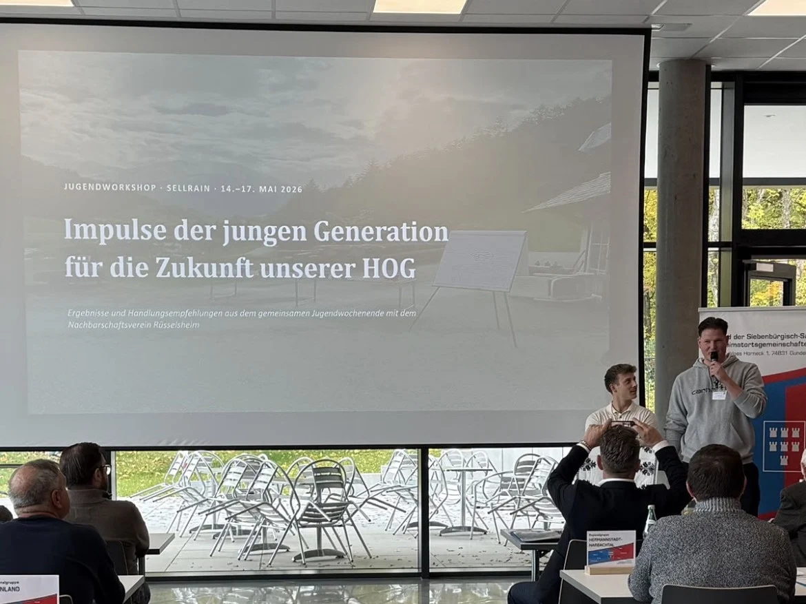 Zwei junge Referenten stellen vor der Leinwand den Vortrag „Impulse der jungen Generation für die Zukunft unserer HOG“ vor, Ergebnisse des Jugendworkshops in Sellrain vom 14. bis 17. Mai 2026; im Vordergrund Zuhörer an Tischen